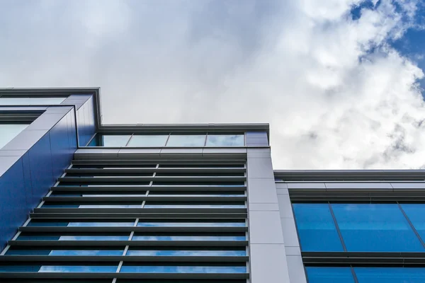 Upprätt Modern kontorsbyggnad med vita moln — Stockfoto