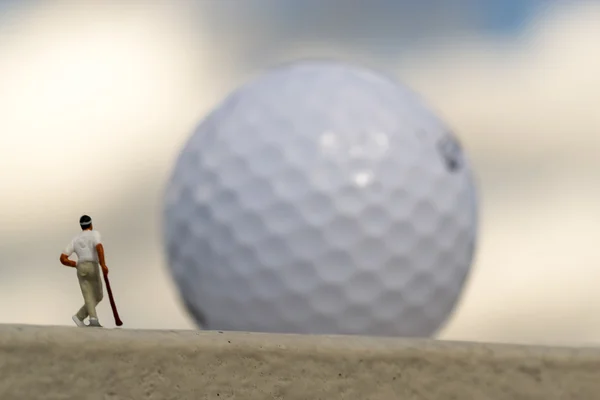 Golfista en miniatura y gigante borrosa Golfball —  Fotos de Stock