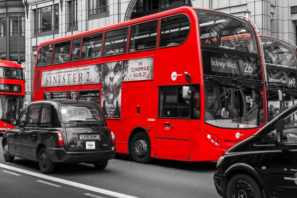 Современные красные автобусы и черные кабины в лондонском Bishopsgate — стоковое фото