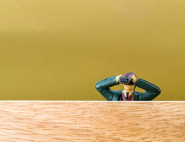 Modelo masculino con prismáticos espías sobre una pared de madera —  Fotos de Stock