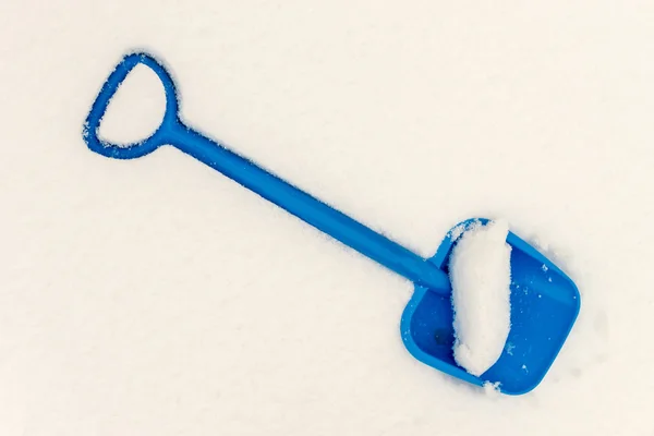 Pelle en plastique bleu dans la neige — Photo