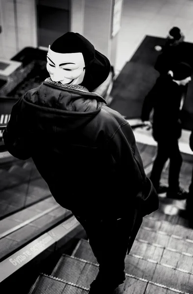 Jóvenes encapuchados usando una máscara Vendetta — Foto de Stock