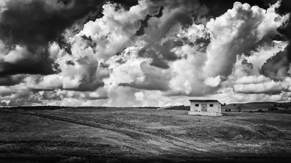 Cabane simple et nuages dramatiques B & W — Photo