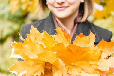Sonbahar park arka plan yaprakların üzerinde güzel esmer kadın