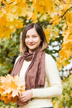 Sonbahar park arka plan yaprakların üzerinde güzel esmer kadın