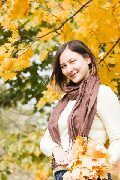 Beautiful brunette women in autumn park on a background of leaves