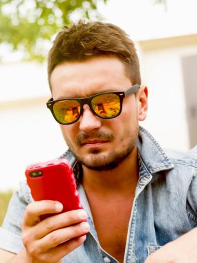 man using mobile smart phone at summer outdoor. clipart