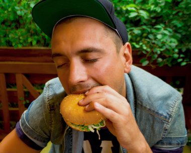 happy young man with a big hamburger