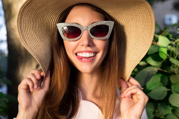 Summer fashion close up portrait of Beautiful young hipster girl. Fashion.Portrait of pretty cheerful woman wearing white dress and straw hat in sunny warm weather day.Walking at summer park, smiling — Stock Photo, Image