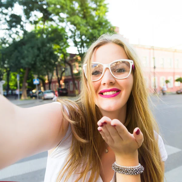 Close up portrait of exciting happy blondy young woman that is dancing in the street, wearing white dress and clear glasses. Crazy emotions, positive lifestyle. Amazing summer day. — Stock Photo, Image