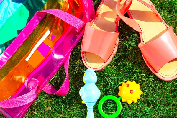 Zapatos de mujer, juguetes y bolso en hierba verde — Foto de Stock