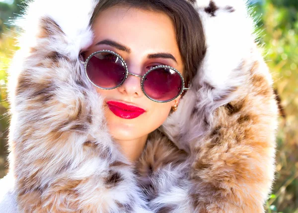 Moda de cerca Retrato de mujer atractiva y elegante con labios rojos con abrigo de piel y gafas de sol retro de moda —  Fotos de Stock