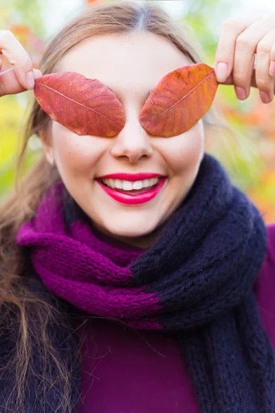 Cute Girl holding in hands maple leaves — Stok fotoğraf