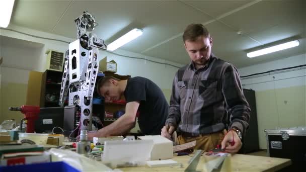 Dos hombres reparan el robot en el taller — Vídeos de Stock