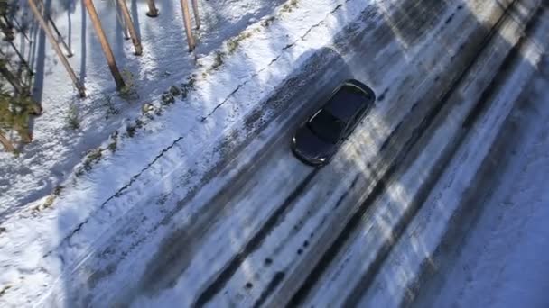 De auto rijdt op een winter weg tussen de bossen en bergen — Stockvideo