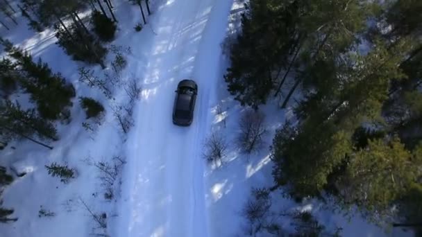 Автомобіль їде на зимовій дорозі серед лісів і гір — стокове відео