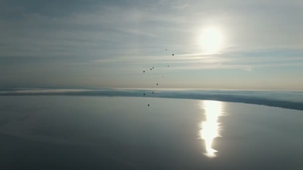 Heißluftballons fliegen über den See — Stockvideo