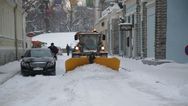 在大雪中工作在街道上的塔林的塔林，爱沙尼亚-2016 年 1 月 5 日: 除雪设备 — 图库视频影像