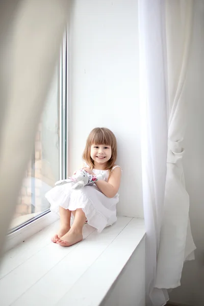 Очаровательная девушка сидит у окна — стоковое фото