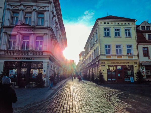 Sun glare in the lens. Street in a city in Europe. A picturesque street without people. Empty alley. City during the pandemic.