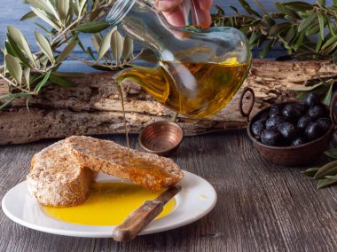 Akdeniz diyetinin tipik bir örneği olan kepekli buğday ekmeğine yağ döken bir sürahi petrolle ve bakır kasede siyah zeytinlerle dolu bir hayat..