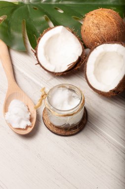 Yine de iki hindistan cevizi hayatı var, biri ikiye bölünmüş, bir kavanoz hindistan cevizi yağı ve ahşap çatalla..