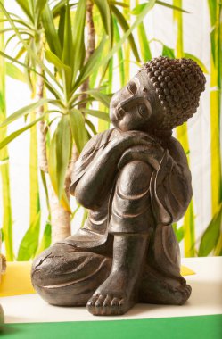 Bambu arka planda bir Buda manzarası. Taşlar, palmiye ağaçları ve havlular.