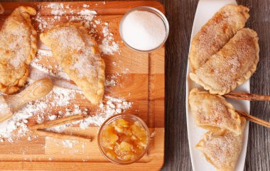 İçinde karamelli elma kreması, bir torba un, bir kavanoz elma kreması, bir kavanoz şeker ve ahşap oklu iğne olan tahta bir tahta tahta tahta tahta tahta kavram..