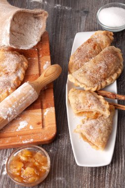 İçinde karamelli elma kreması, bir torba un, bir kavanoz elma kreması, bir kavanoz şeker ve ahşap oklu iğne olan tahta bir tahta tahta tahta tahta tahta kavram..