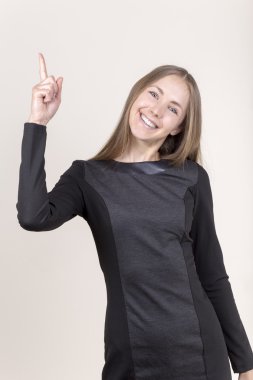 işaret parmağı gösterilen siyah elbiseli gülümseyen genç kadın