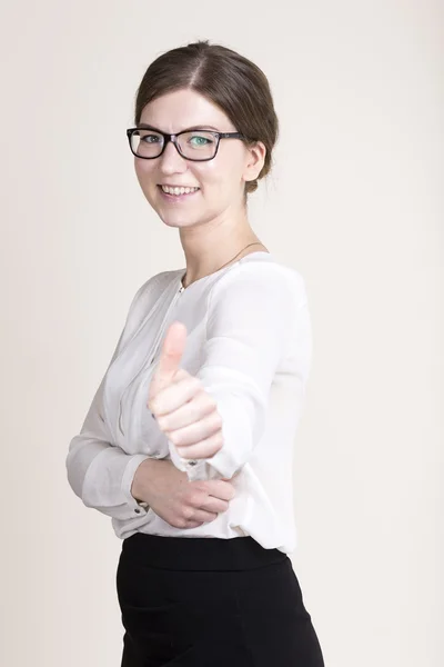 Femme d'affaires réfléchie avec des lunettes en chemise blanche et jupe noire montrant pouces vers le haut. se concentrer sur le visage — Photo