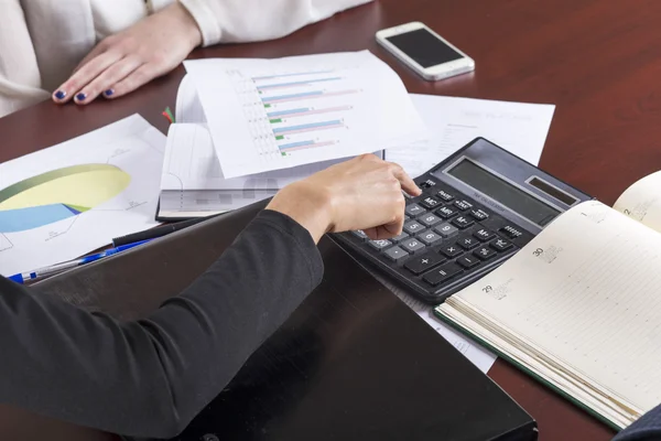 Geschäftsfrau arbeitet mit Taschenrechner im Büro — Stockfoto