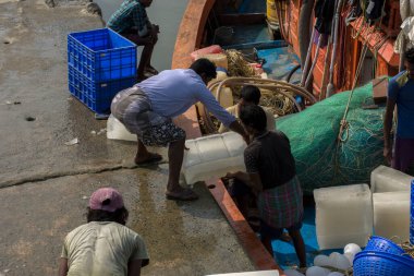09 Ocak 2021 'de. Fresergunj, Batı Bengal, Hindistan. Bazı balıkçılar bir parça buzu tekneye itiyor. Bu da denize açılmadan önceki hazırlığın bir parçası..