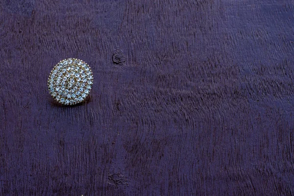 Tahta yüzeyinde elmaslar olan güzel gümüş bir yüzük.