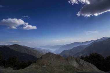 Dağ katmanları mavi gökyüzü ve beyaz bulutlar