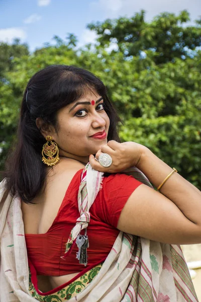 Geleneksel Bengali sarisi içinde güzel bir Hint kadın modeli. Sarı arka planda gülümseyen hafif bir yüzle ve metin için kopya alanı ile mutlu görünüyor. Neşeli ruh hali