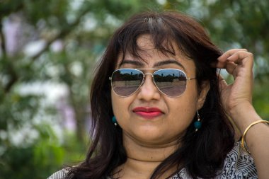 Hintli, genç, güzel, güneş gözlüklü kadın model.