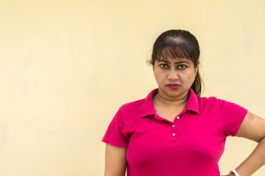 Hintli kadın model sarı arkaplanda kızgın bir yüz ve metin için fotokopi alanı var. Öfkeli ruh hali konsepti.