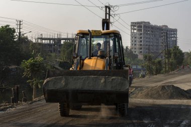 14 Mart 2021 Narendrapur, Batı Bengal, Hindistan: Bir yerden başka bir yere bir buldozer bakım yol malzemesi. Seçici odak.