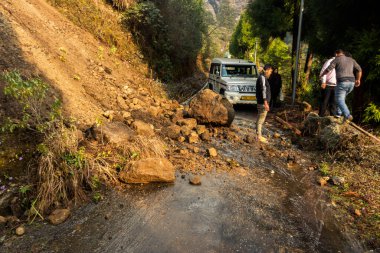 2 Nisan 2021, Lachung, Sikkim, Hindistan: Lachung köyünde toprak kayması ve bir araba takıldı ve birkaç yerli yolu temizlemeye çalışıyor..