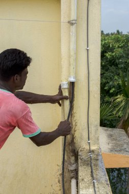 22 Mayıs 2021, Kolkata, Batı Bengal, Hindistan: Erkek bir tesisatçı ince bir kabloyla PVC borularını temizliyor. Seçici odak.