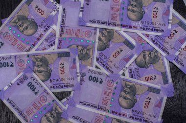 Siyah arka planda 100 rupilik Hint para birimi banknotları. Seçici odak.