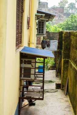 Pencereli bir klima makinesi ve klima makinesi aynı duvarda, gölgeli. Seçici odak.