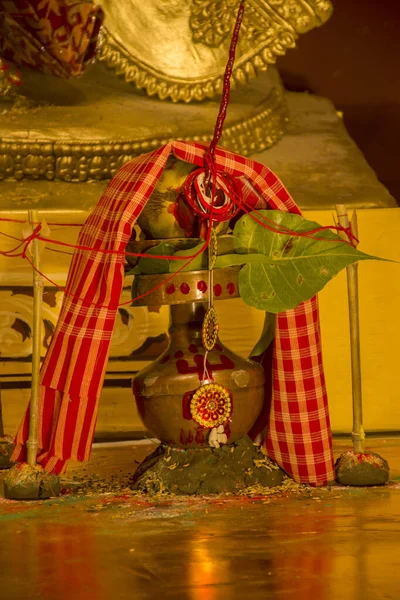 Bruss kalash with raw coconut and mango leavs and a cotton towel for Hindu festivals with selective focus.