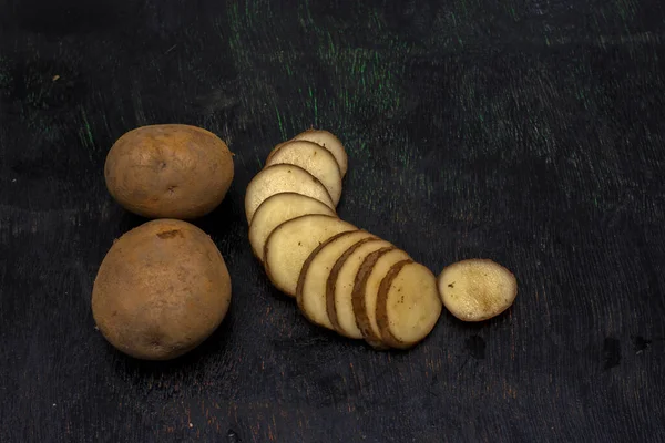 Two Whole Potatoes Sliced Potato Dark Background Selective Focus — Stock Photo, Image