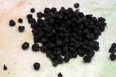 Beyaz arka planda seçici odaklı kurumuş organik mavi böğürtlen.