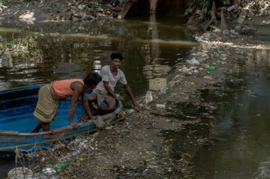 15 Ağustos 2021, Kolkata, Batı Bengal, Hindistan: 15 Ağustos 2021, Kolkata, Batı Bengal, Hindistan: Teknede çöp temizlemeye çalışan iki kişi.