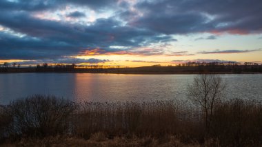 Sakin gölün üzerinde güzel bir gün batımı