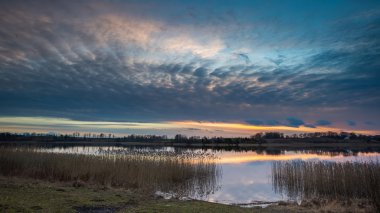 Sakin gölün üzerinde güzel bir gün batımı