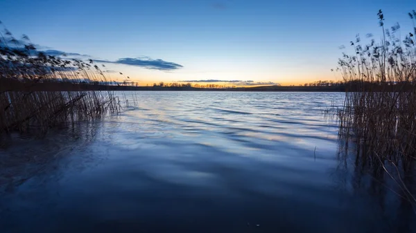 พระอาทิตย์ตกที่สวยงามเหนือทะเลสาบที่สงบ — ภาพถ่ายสต็อก